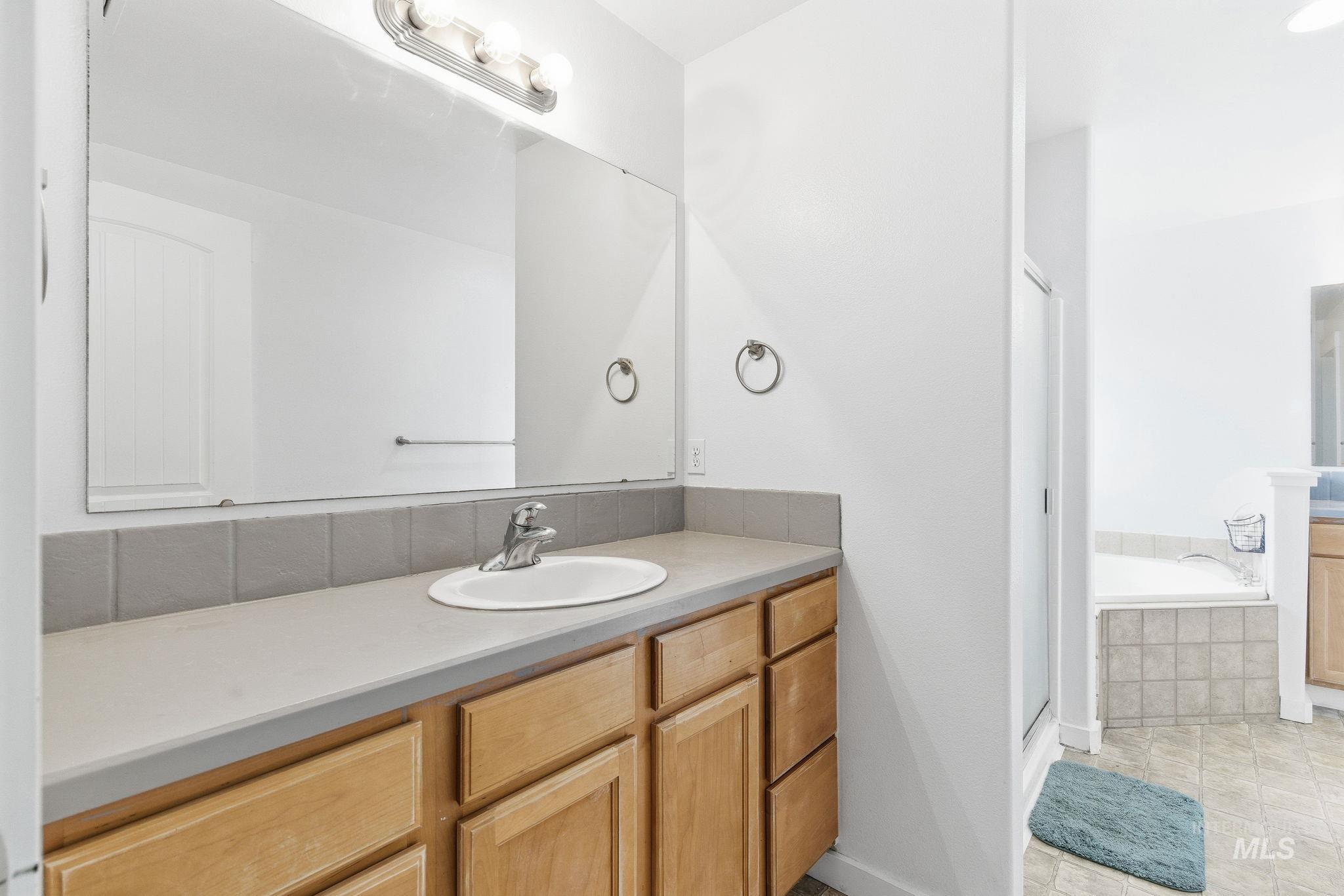Bathroom with vanity, a bath, a stall shower, and light tile patterned flooring