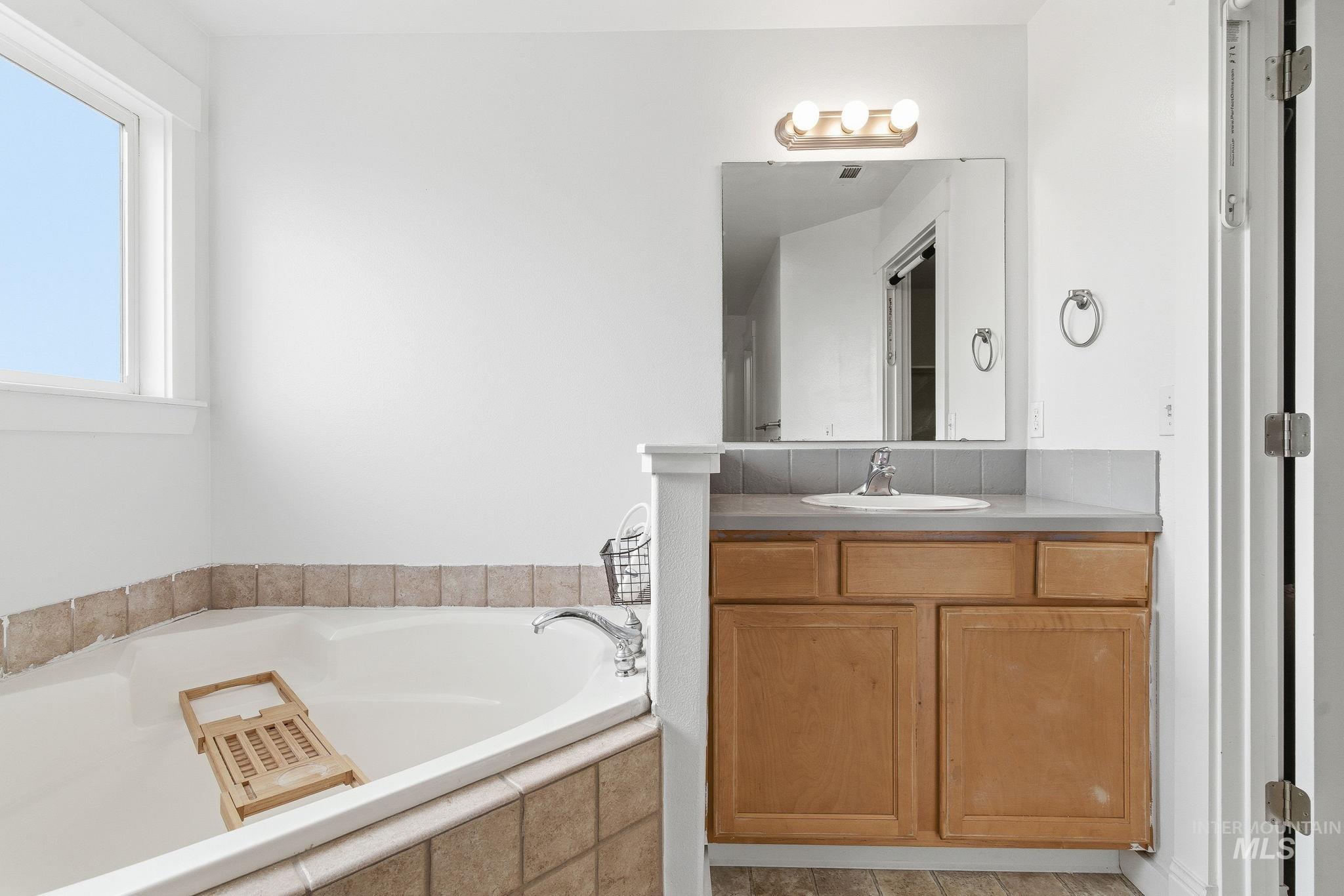 Full bath featuring a bath and vanity