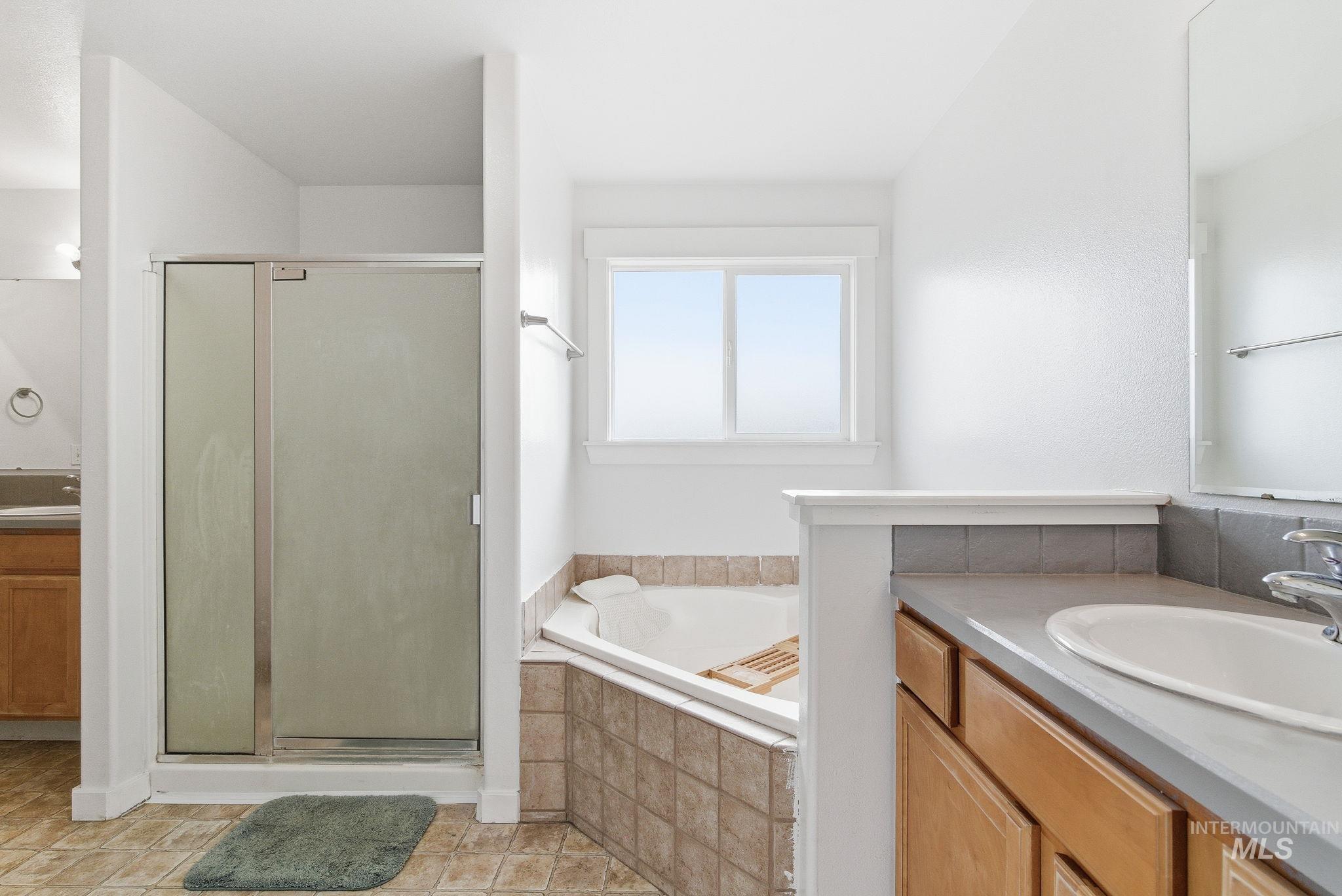 Bathroom with vanity, a stall shower, and a bath