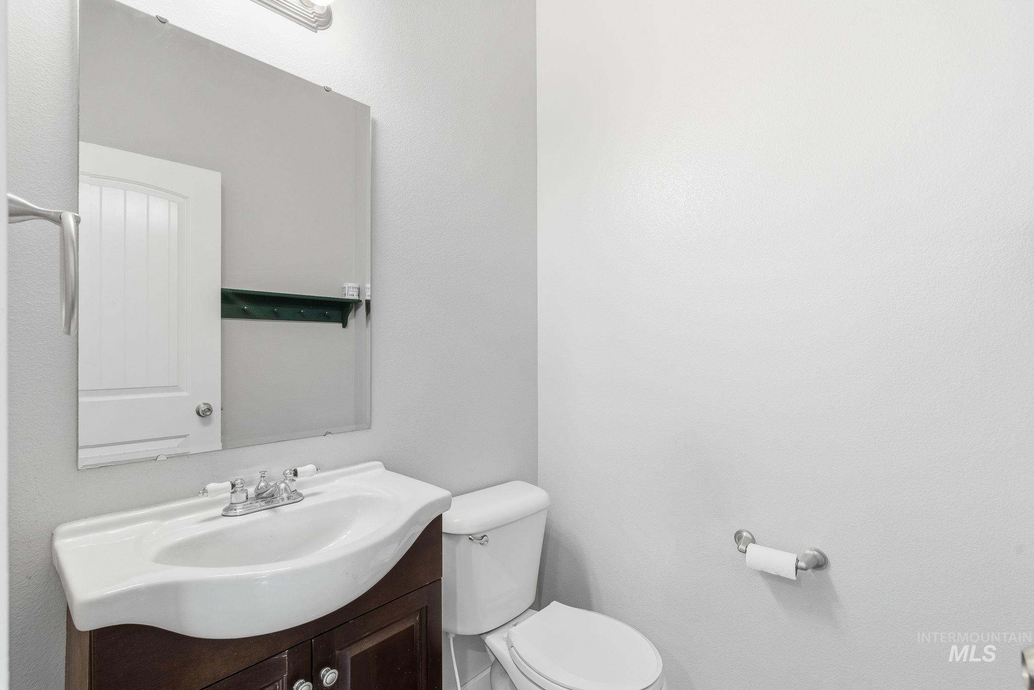 Half bathroom featuring vanity and toilet