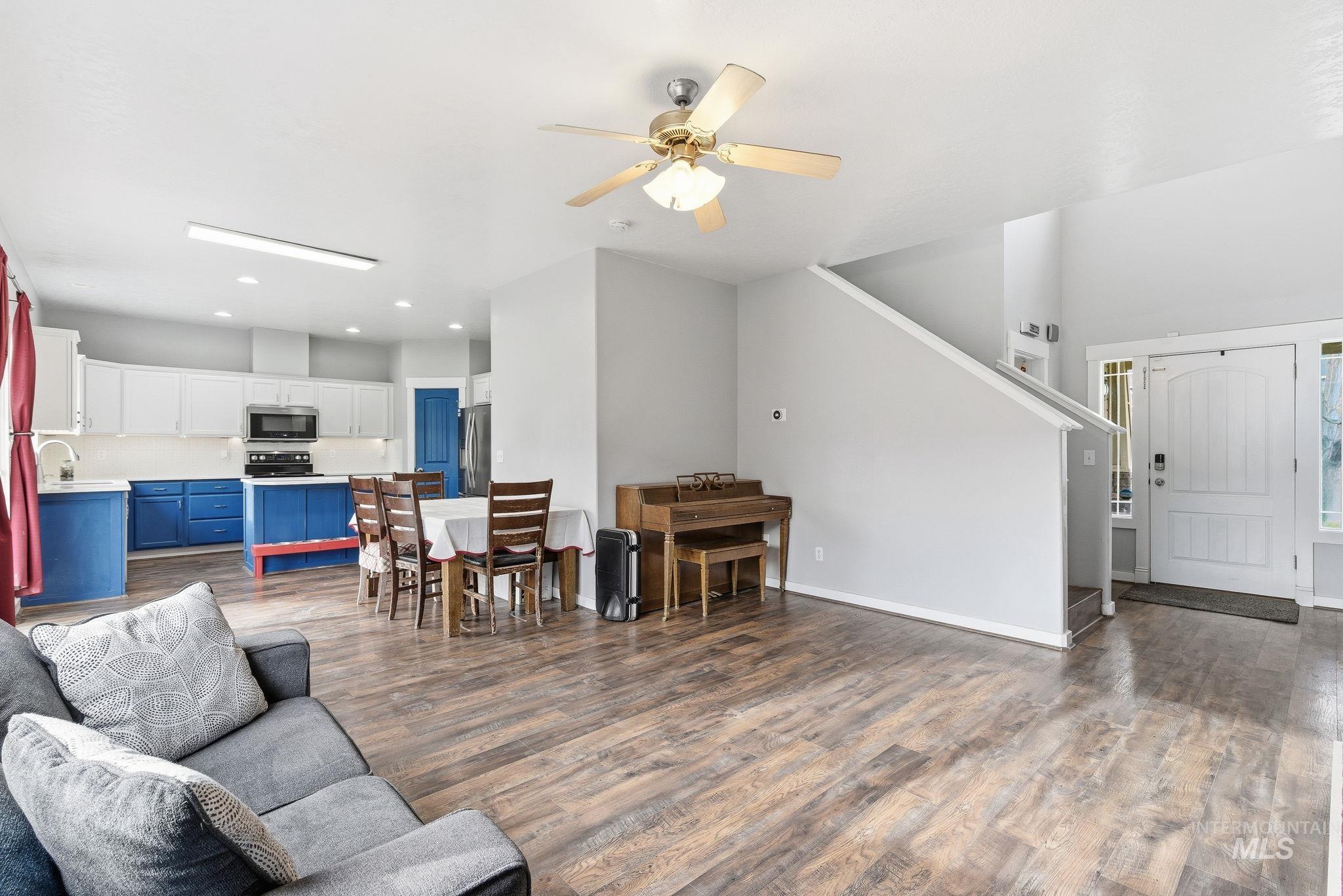 Living room with dark wood finished floors, ceiling fan, and recessed lighting