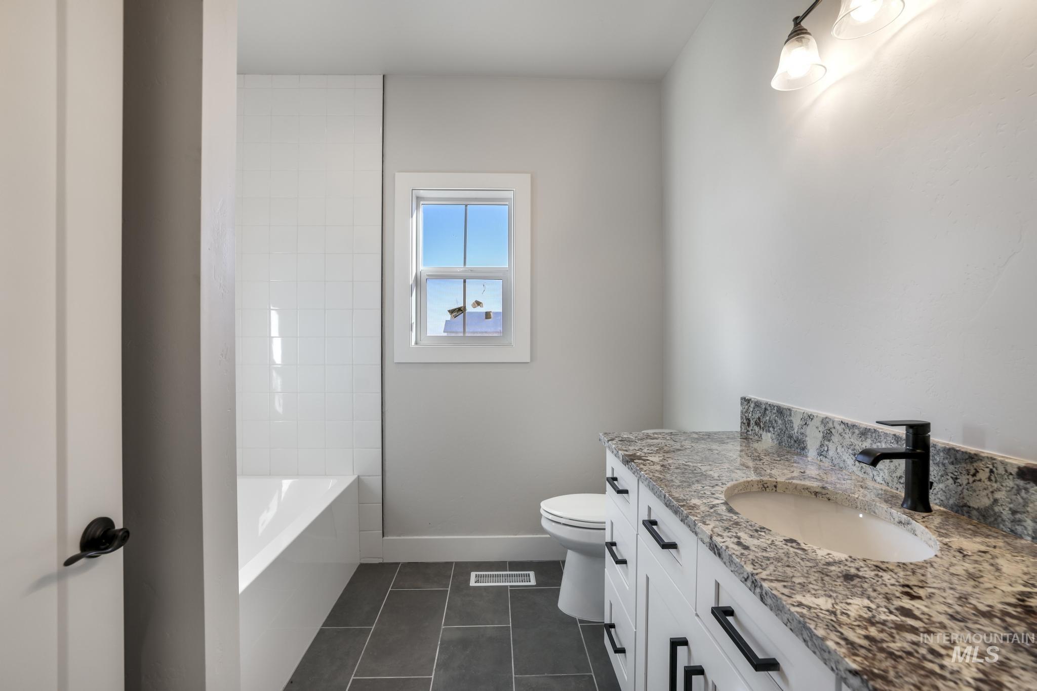 Bathroom featuring vanity and dark tile patterned flooring