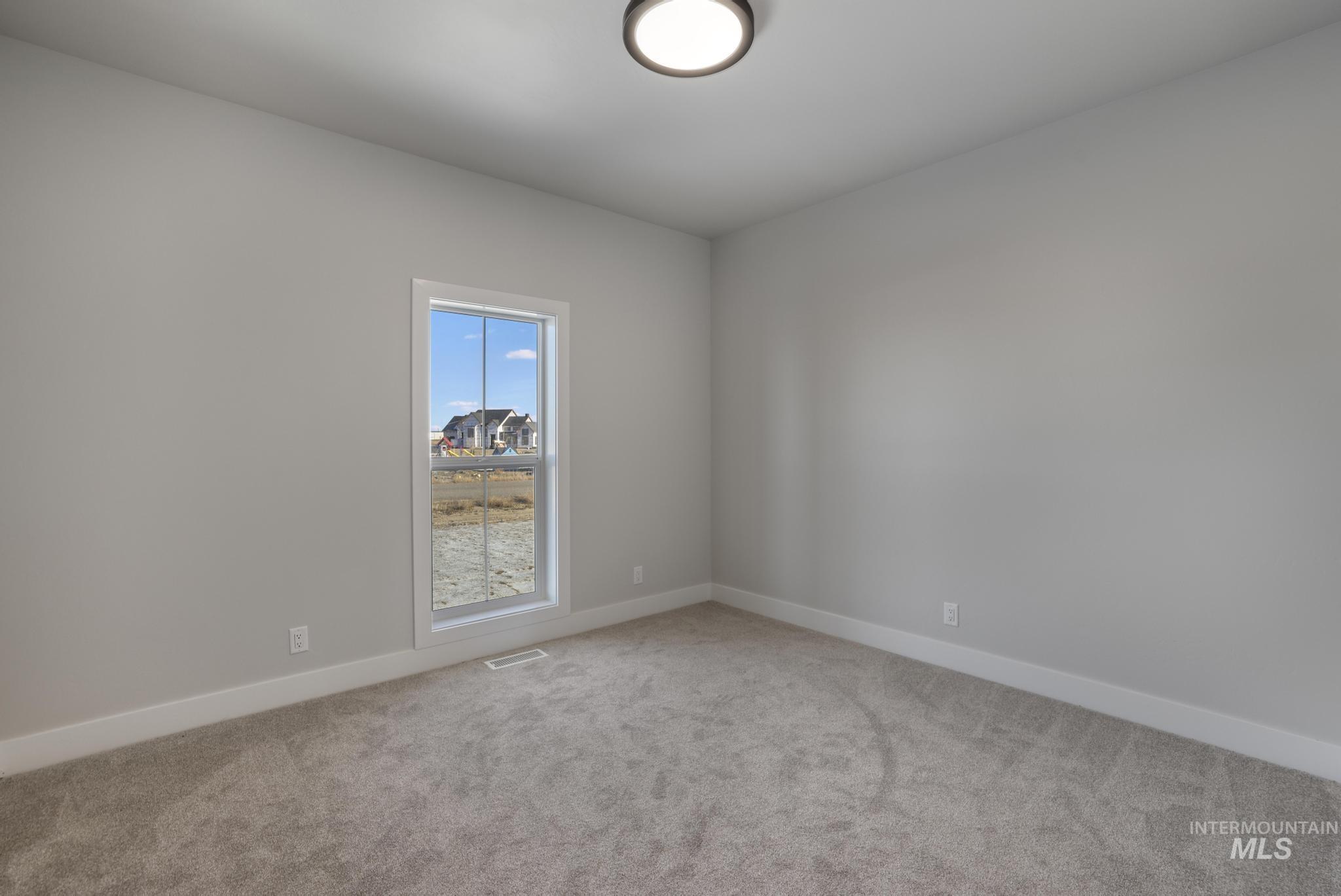 Carpeted empty room featuring baseboards