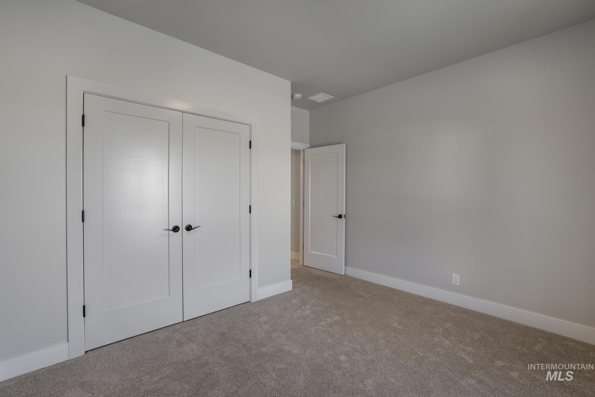 Unfurnished bedroom featuring carpet and a closet