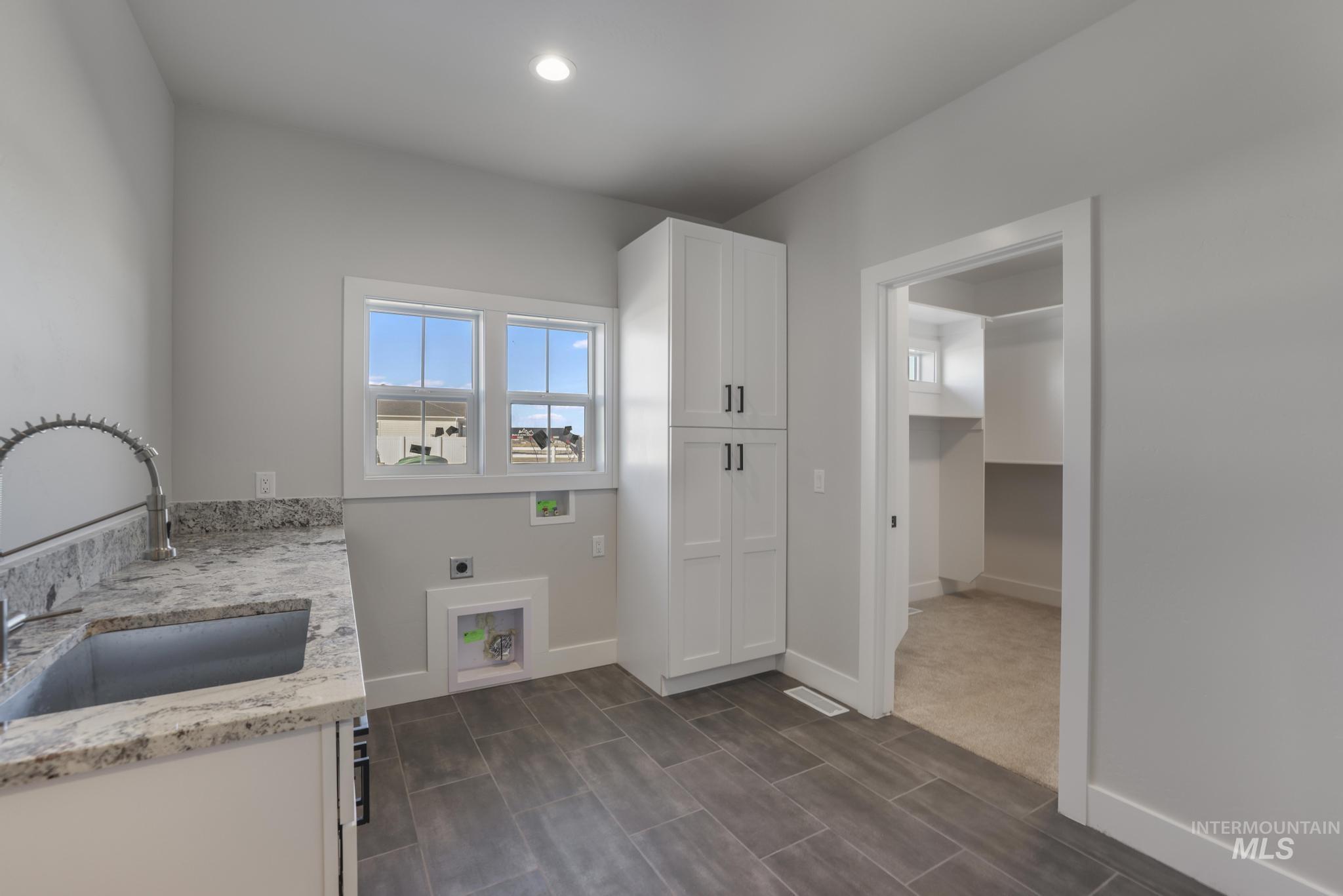 Washroom featuring electric dryer hookup, cabinet space, washer hookup, and recessed lighting