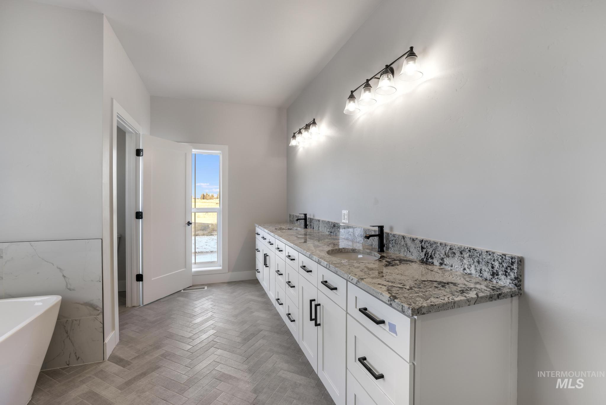 Full bath featuring double vanity and a freestanding tub