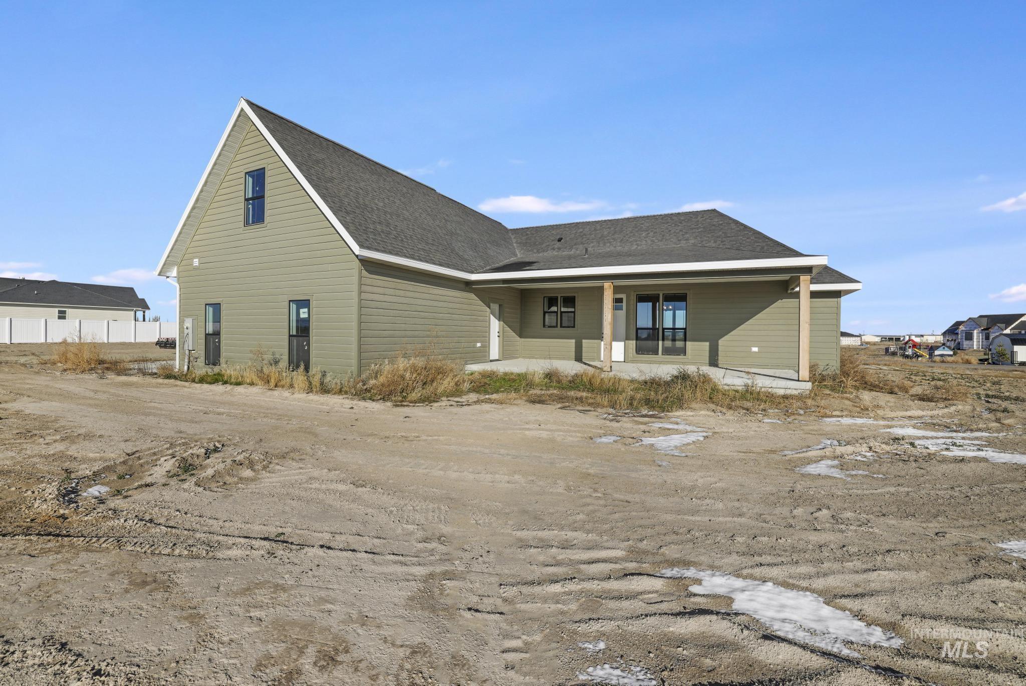 Back of property featuring a shingled roof and a patio area