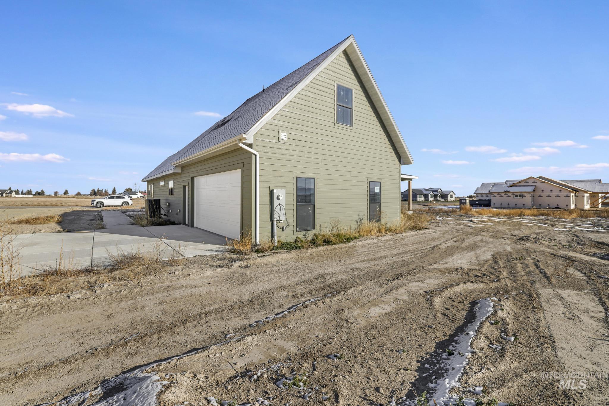 View of home's exterior featuring driveway and a shingled roof