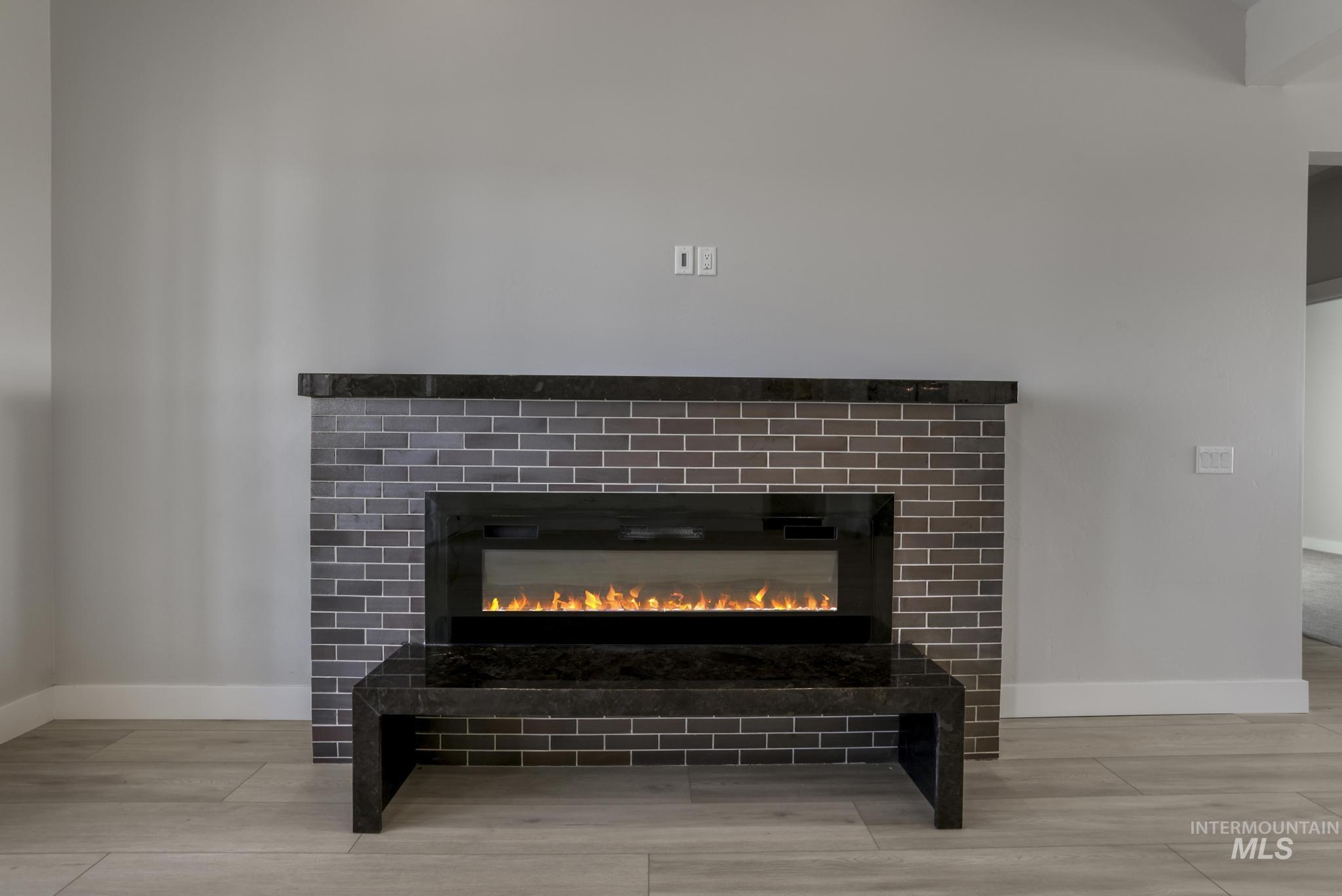 Detailed view of a glass covered fireplace and wood finished floors